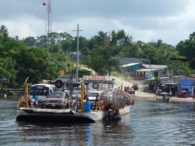 A ferry boat on a river in Guatemala, with thatched roof