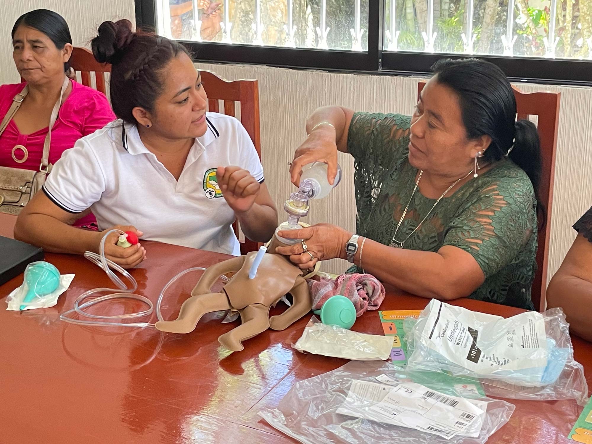 Argelia Rodriquez instructs a midwife in the use of the ambu bag