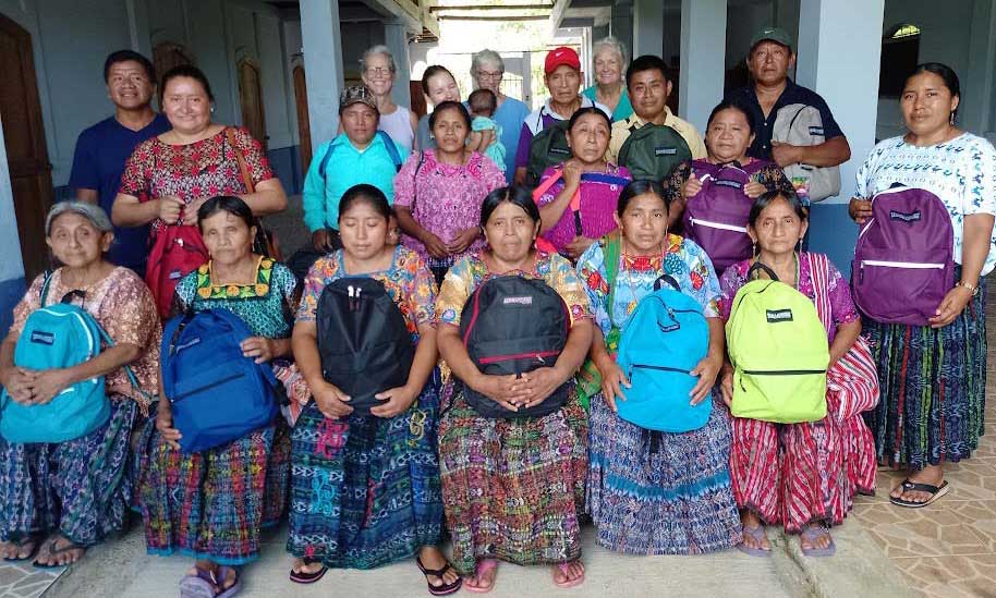 A group of midwives holding their backpacks of supplies