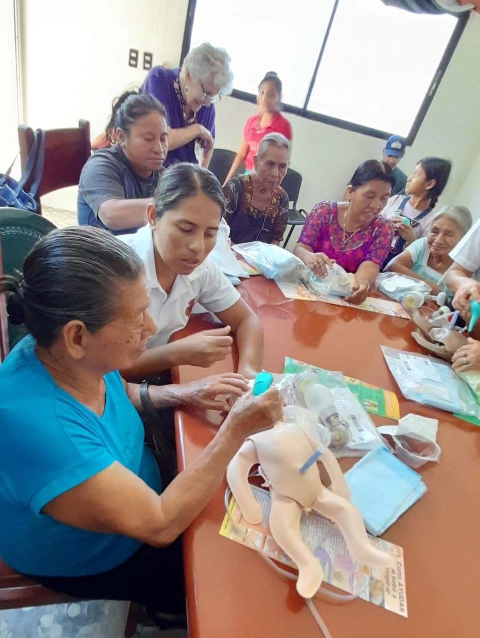 Midwives practicing the use of the ambu bag on a model newborn